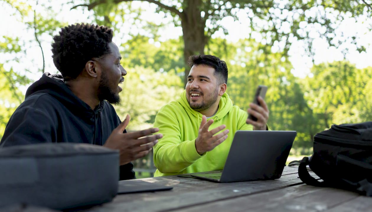 Hands holding smartphone at outdoor café table